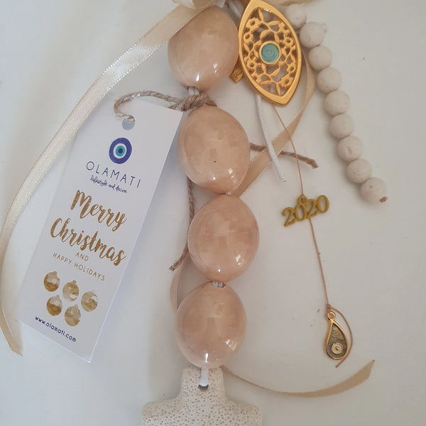 Light brown ceramic bead and mati with a cross wall hanging