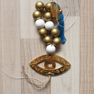 Gold and white mati wall hanging with large wooden beads and gold pomegranate